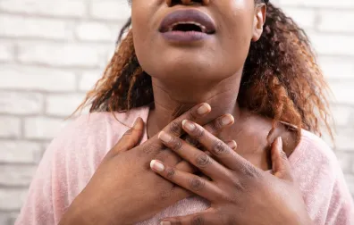 Vrouw grijpt met beide handen naar haar keel