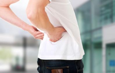 Man met handen op pijnlijke onderrug