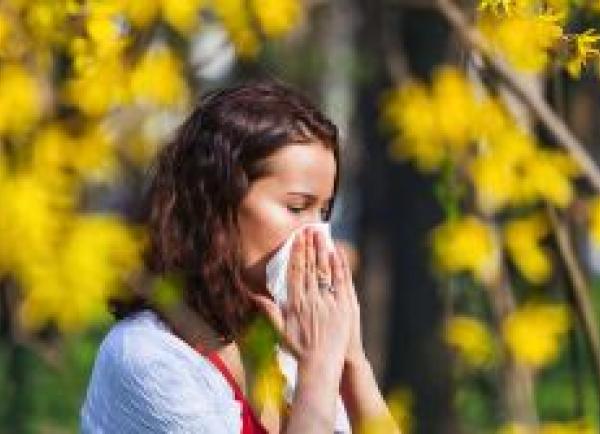 Vrouw snuit neus bij bloeiende bomen