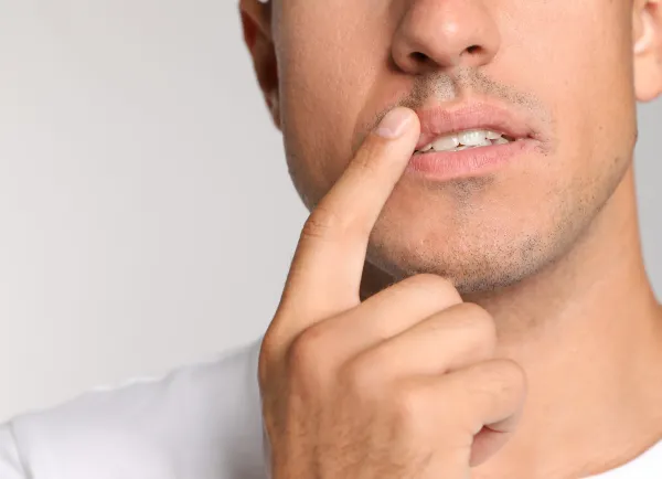 Man houdt vinger op lip