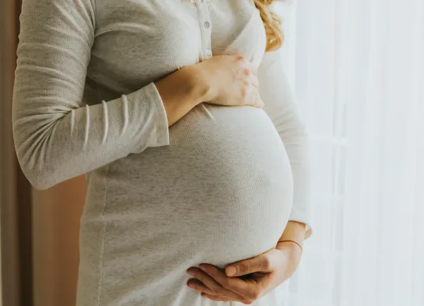 Vrouw met handen op zwangere buik
